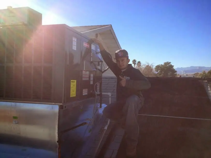 HVAC technician performing Air Duct Cleaning on a rooftop unit in West Modesto